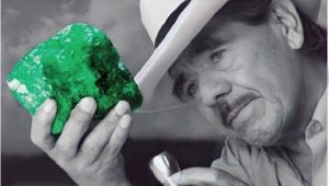 Hombre admirando una piedra preciosa esmeralda de color verde intenso 